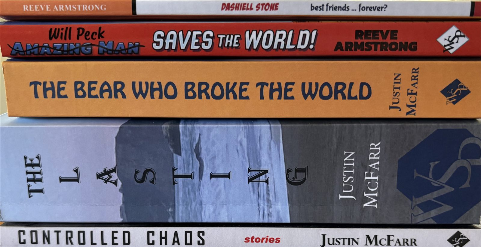 A stack of Justin McFarr's books seen spine-on: Dashiell Stone, Will Peck Saves the World, The Bear Who Broke the World, The Lasting, and Controlled Chaos
